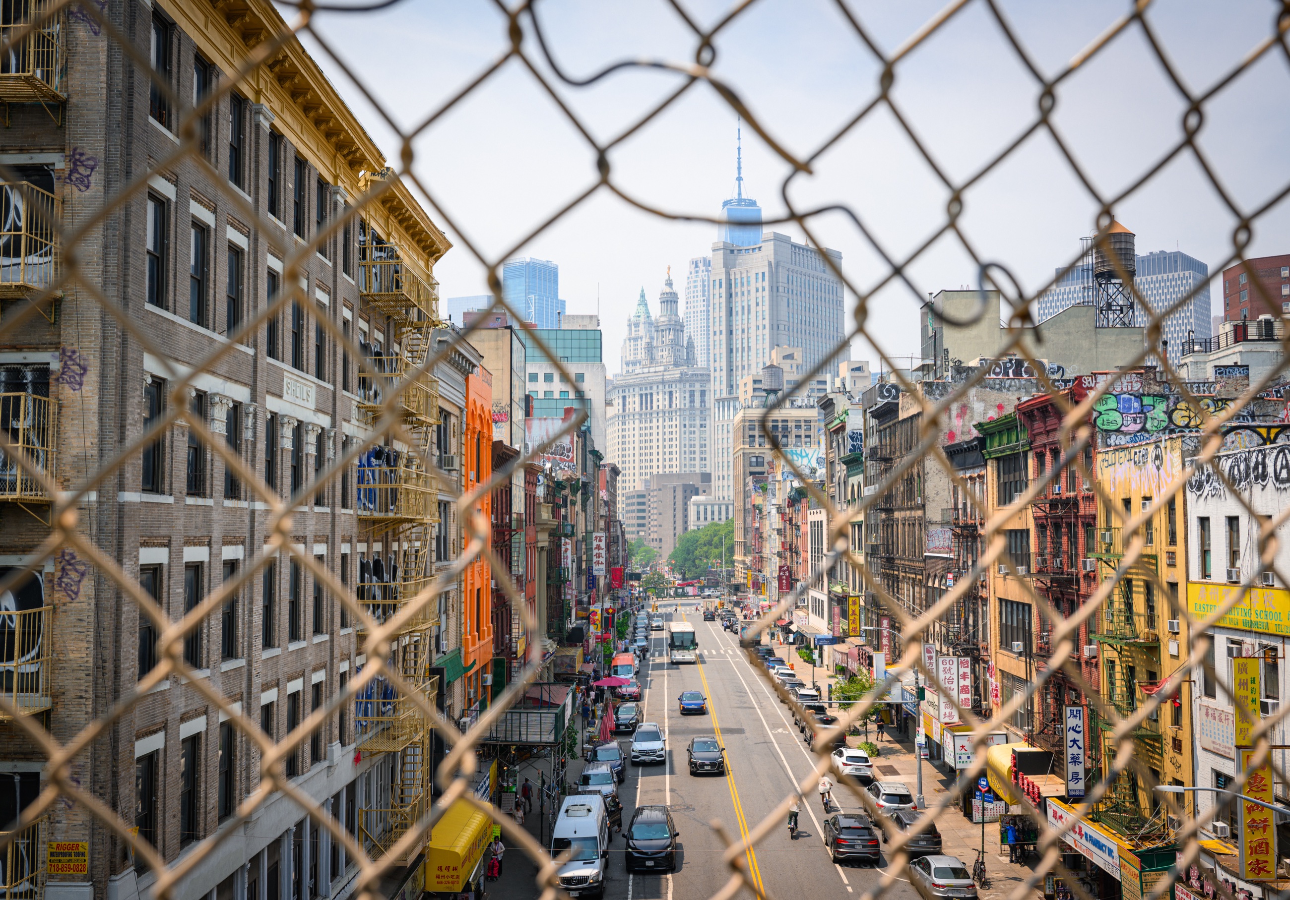 Chinatown seen through a chain-link fence toward Manhattan’s Civic Center